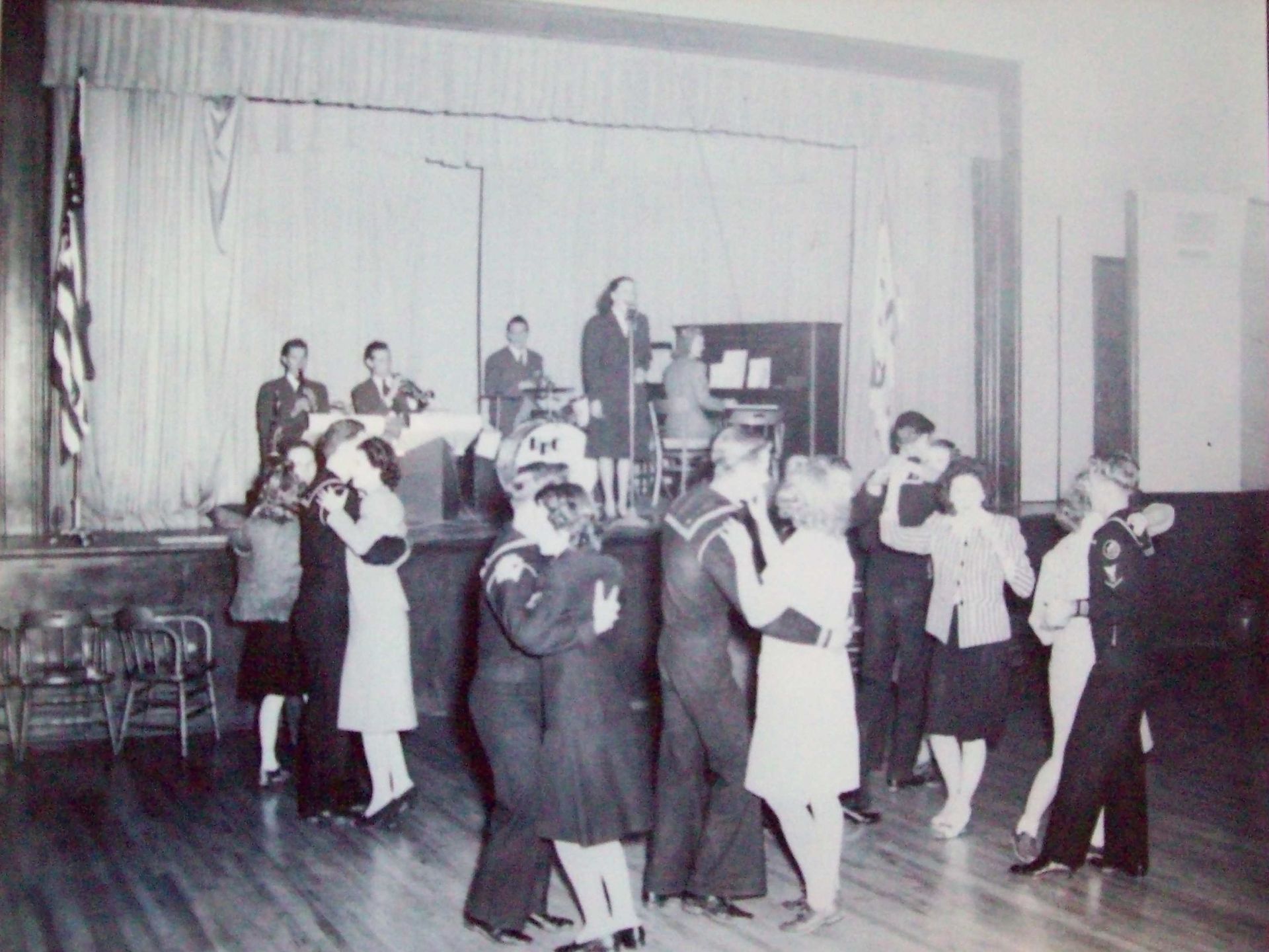 A black and white photo of people dancing on a stage