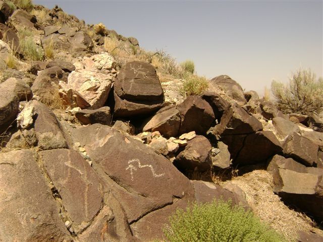 A large pile of rocks with a drawing on one of them