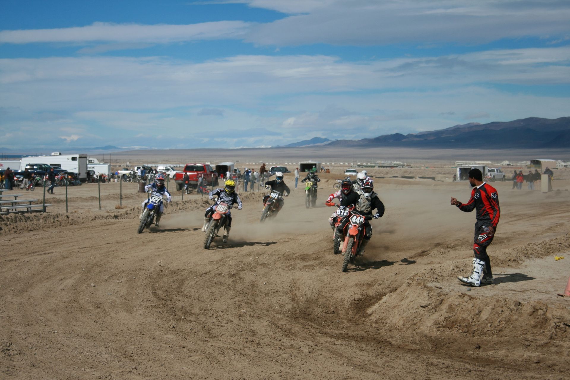 A group of people are riding dirt bikes on a dirt track