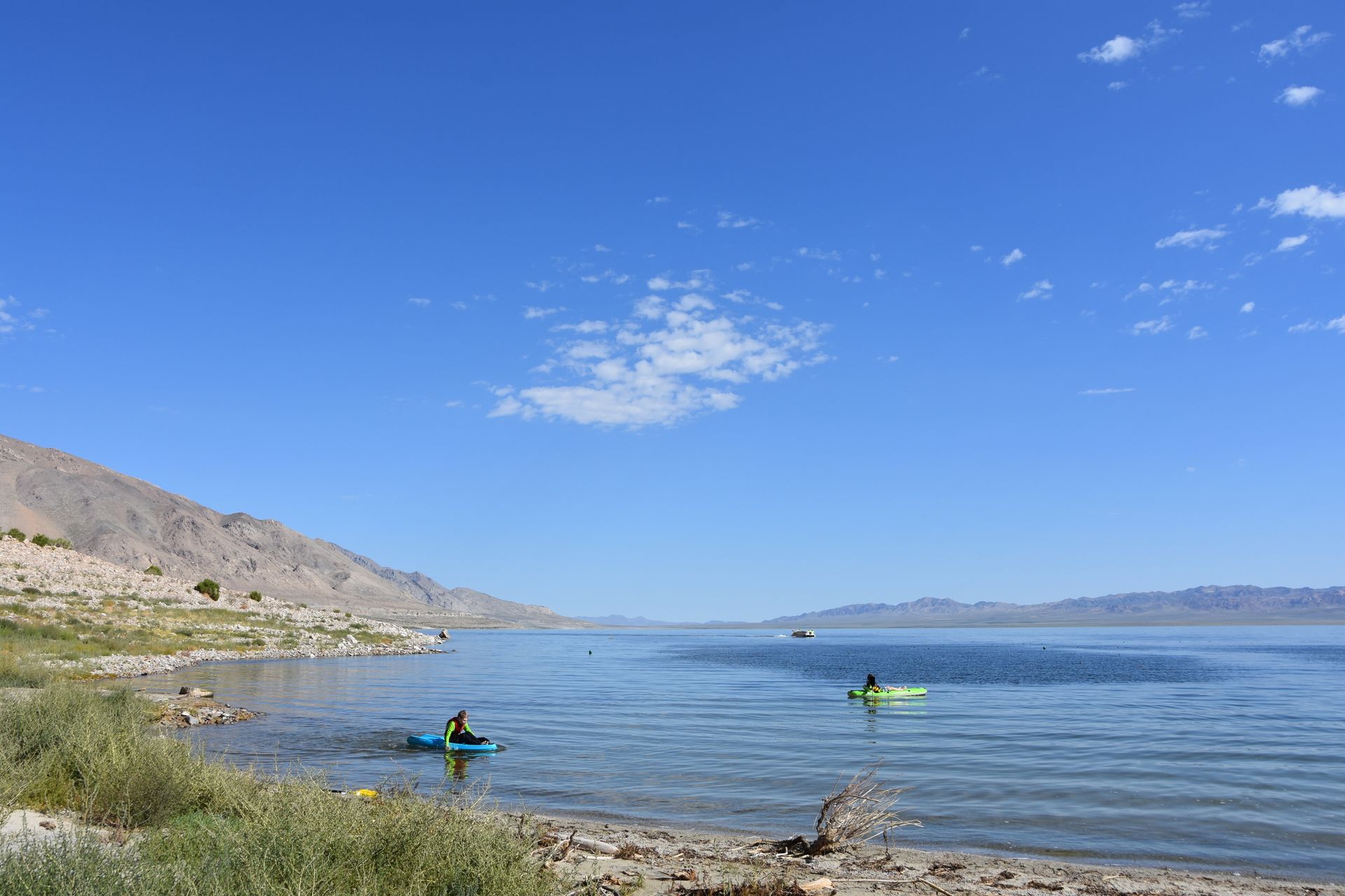 A couple of people are kayaking on a lake.