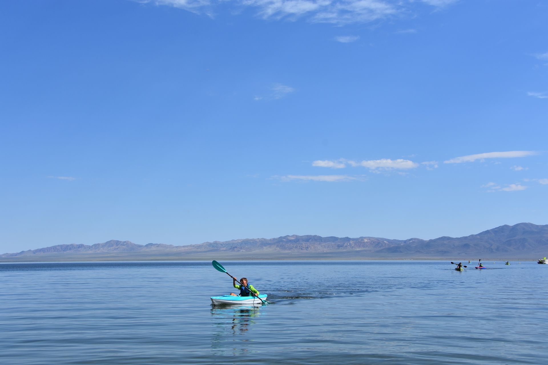 A person is paddling a kayak on a lake.