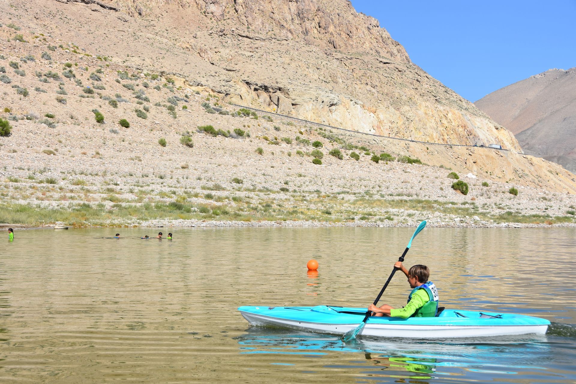 A person is paddling a kayak on a lake.