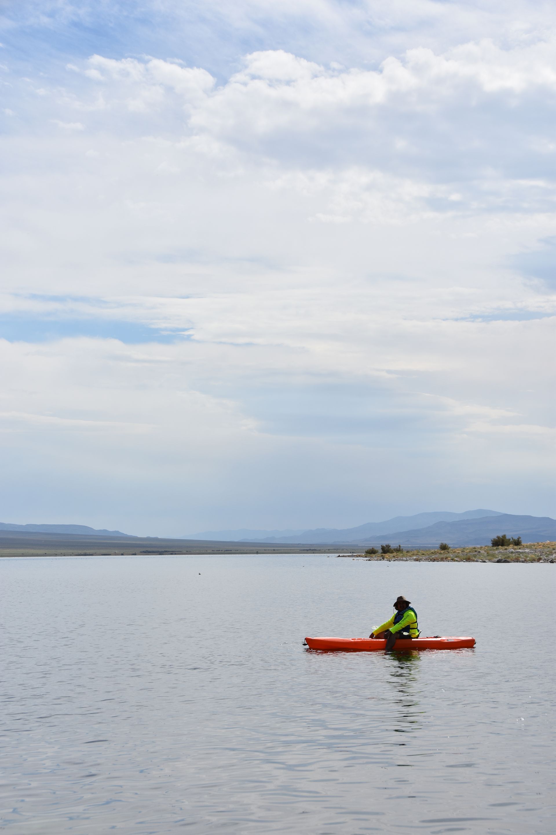 A person is paddling a red kayak on a lake