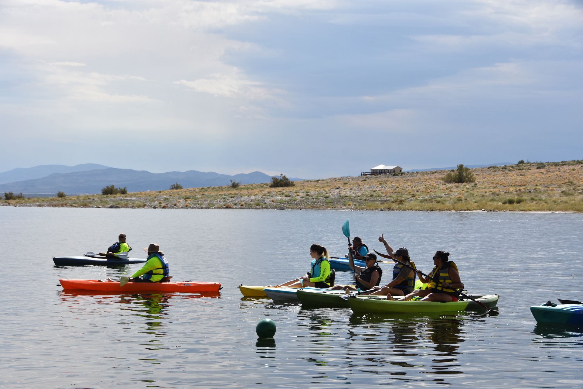 A group of people are riding kayaks on a lake.