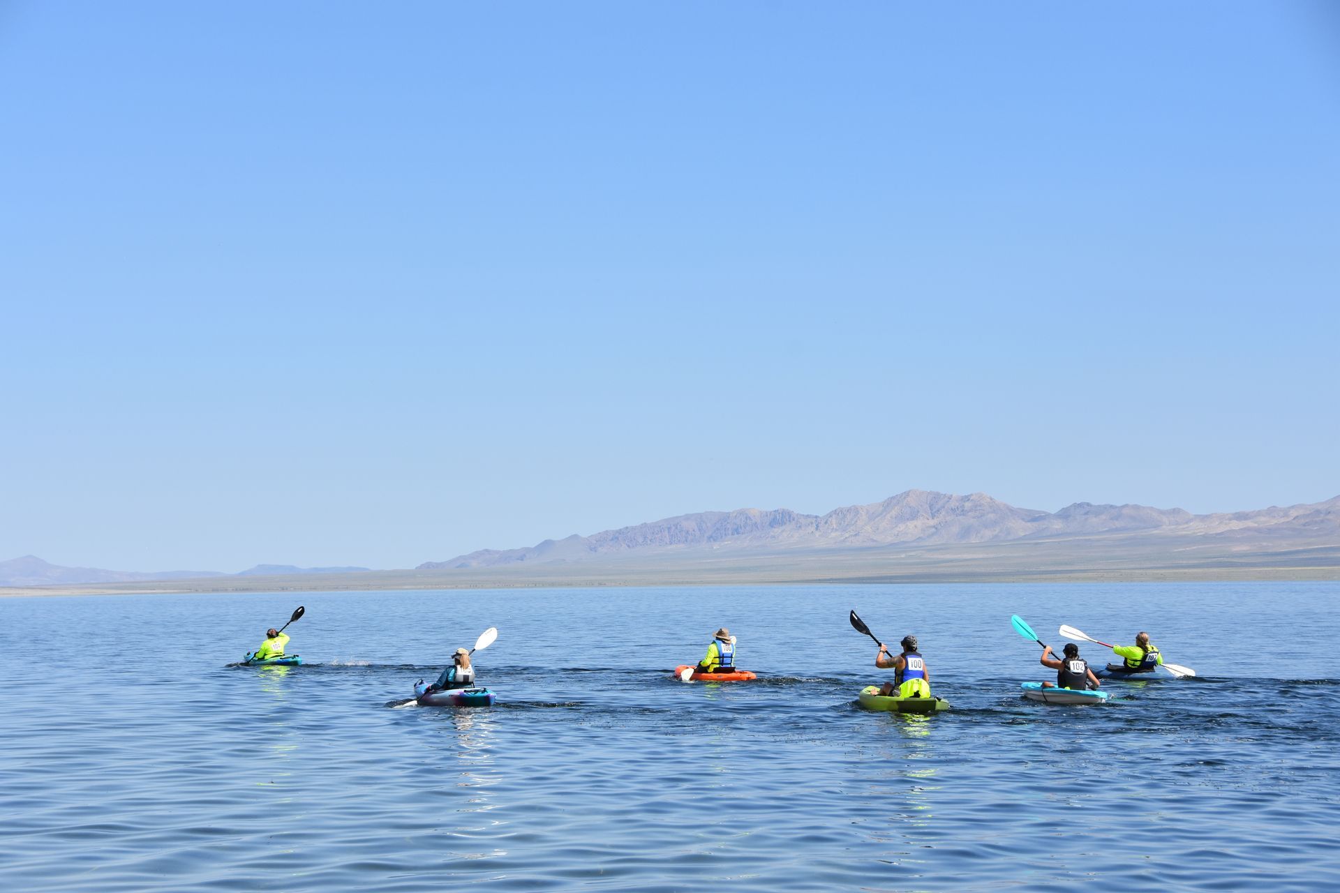 A group of people are kayaking on a lake.