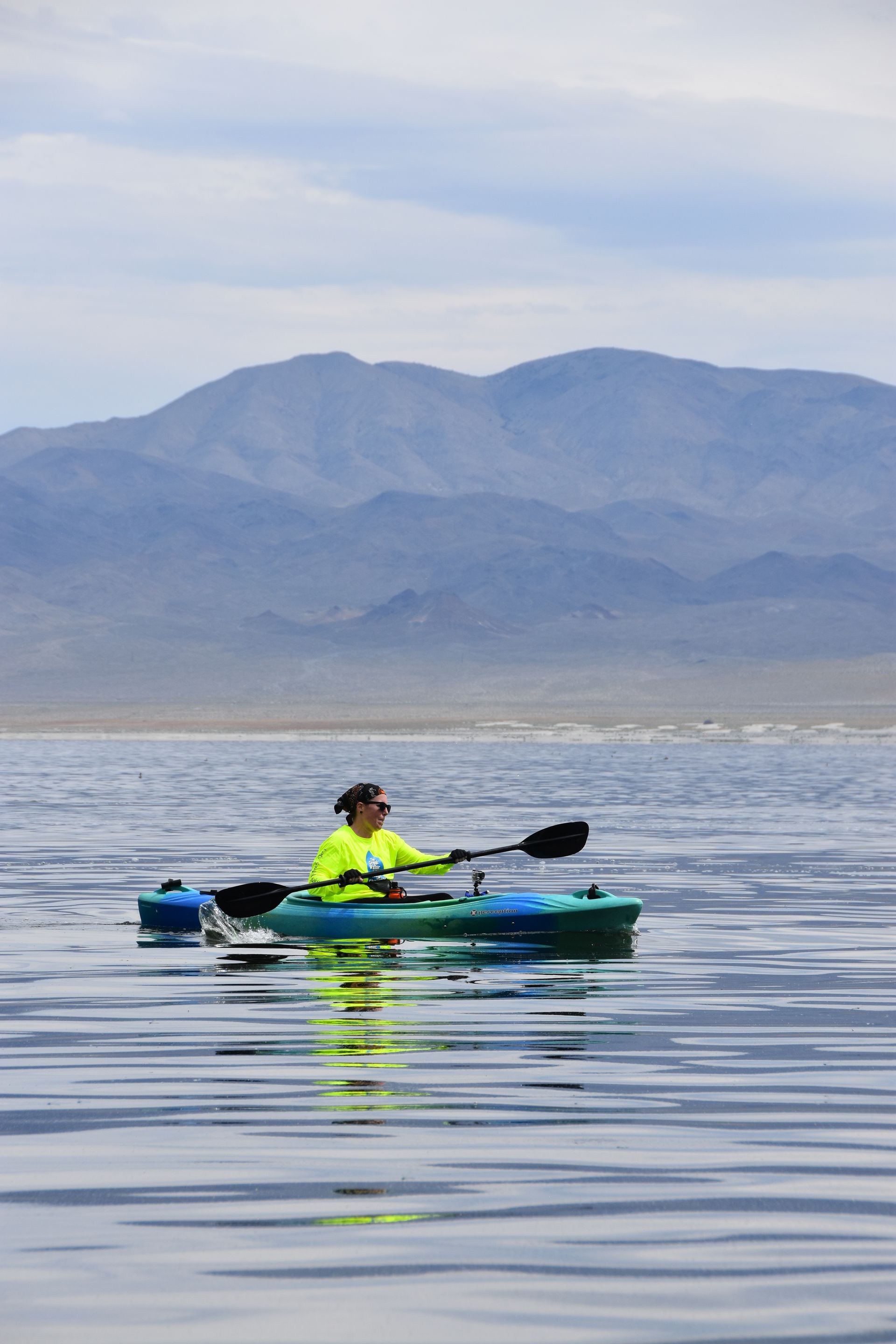 A person in a kayak with mountains in the background