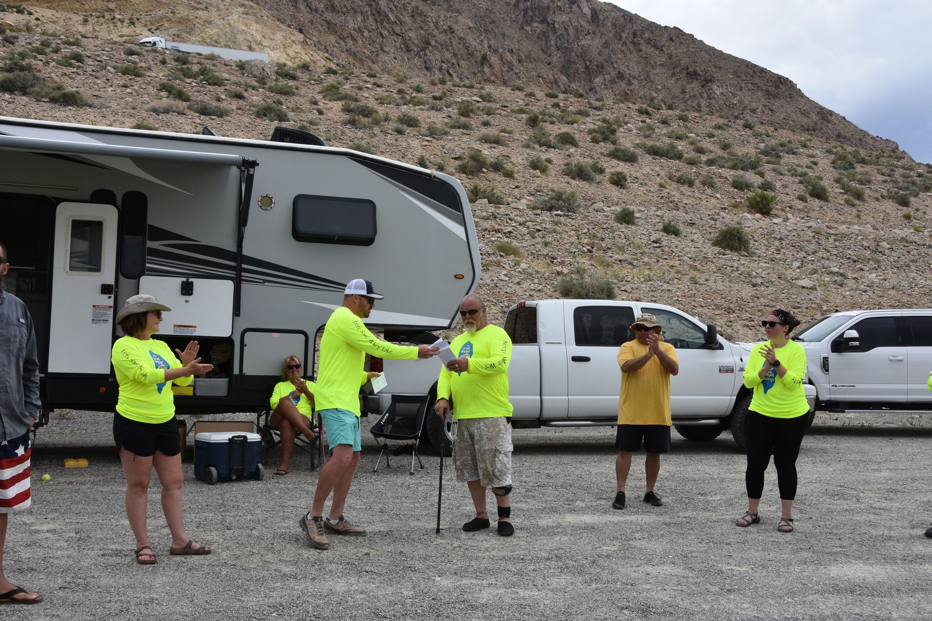 A group of people are standing in front of a rv.