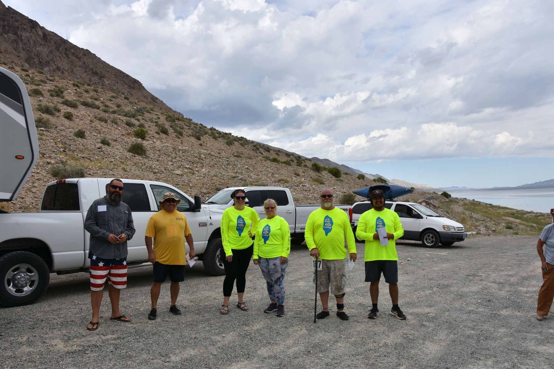 A group of people are standing in front of a white truck.