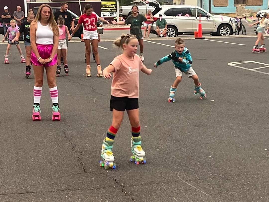 A group of people are rollerblading down a street.