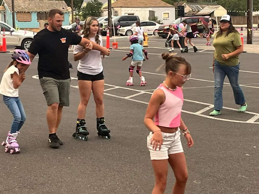 A group of people are rollerblading in a parking lot.