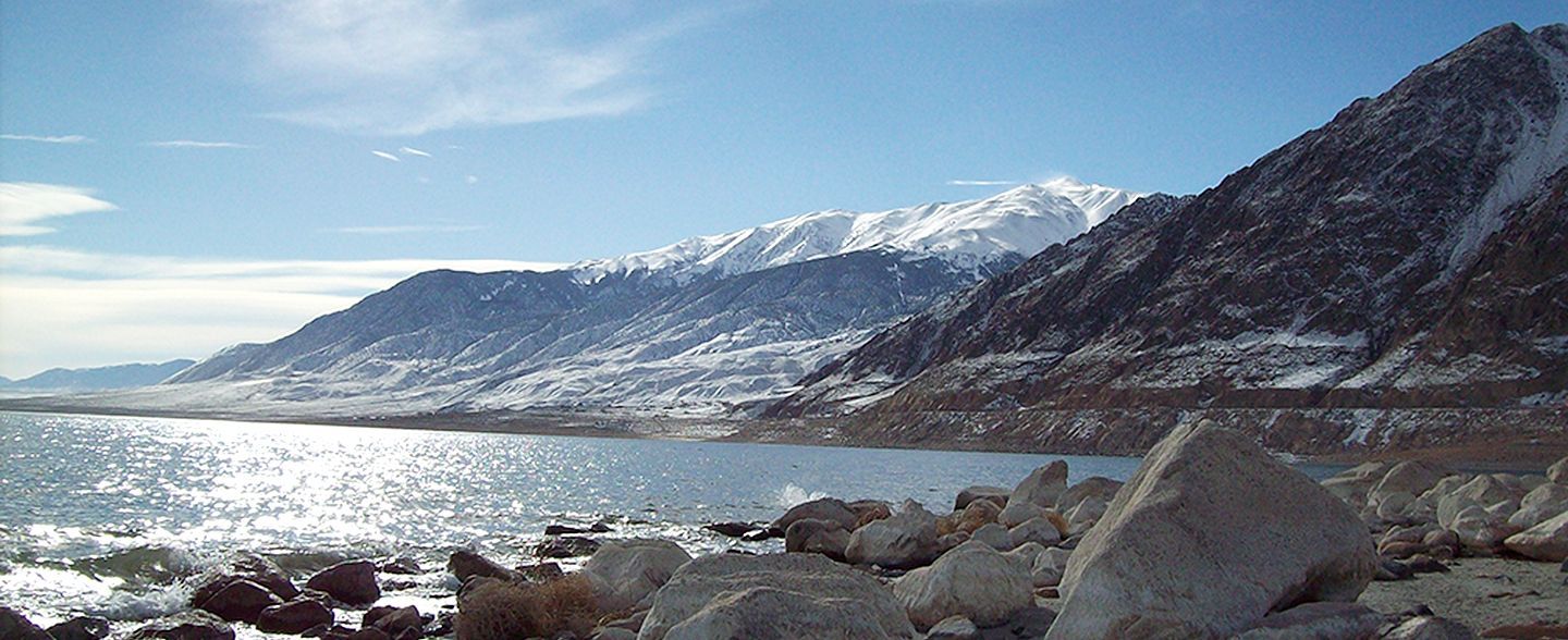 A lake with mountains in the background and rocks in the foreground