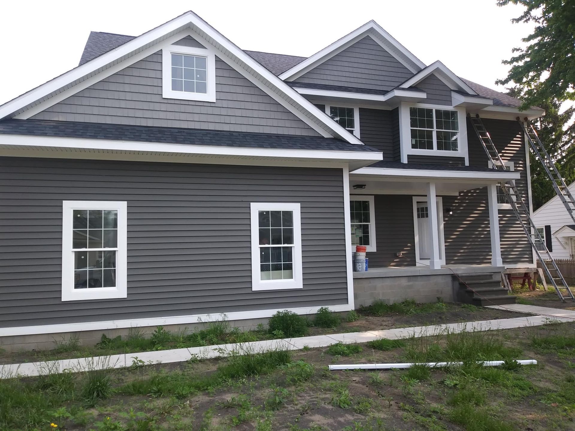 A large house with a gray siding and white trim