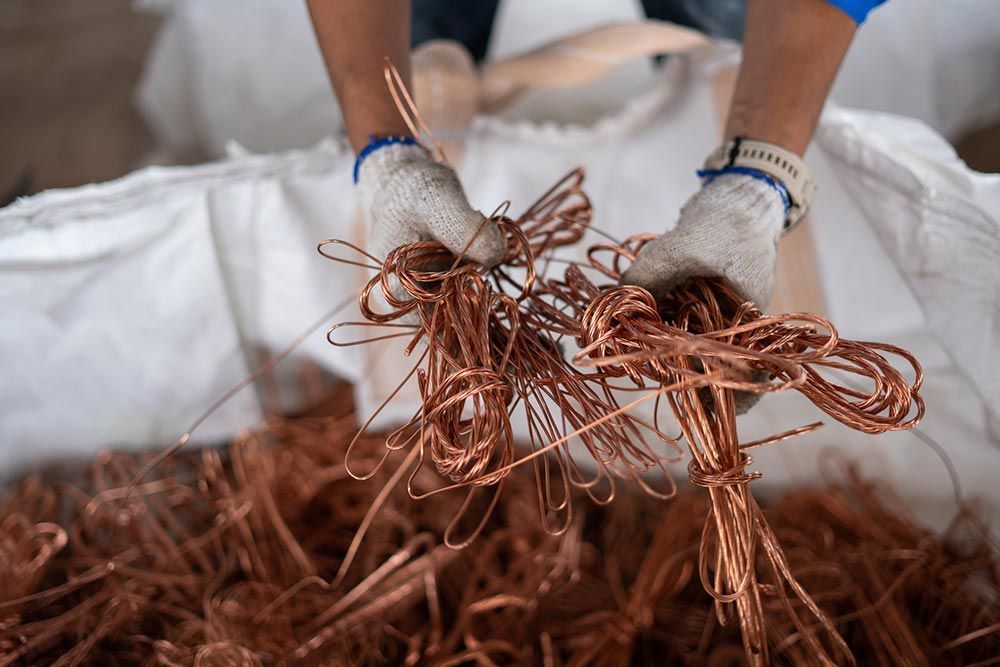 Copper metal bending process in Burbank, CA, performed by a worker in protective gloves.