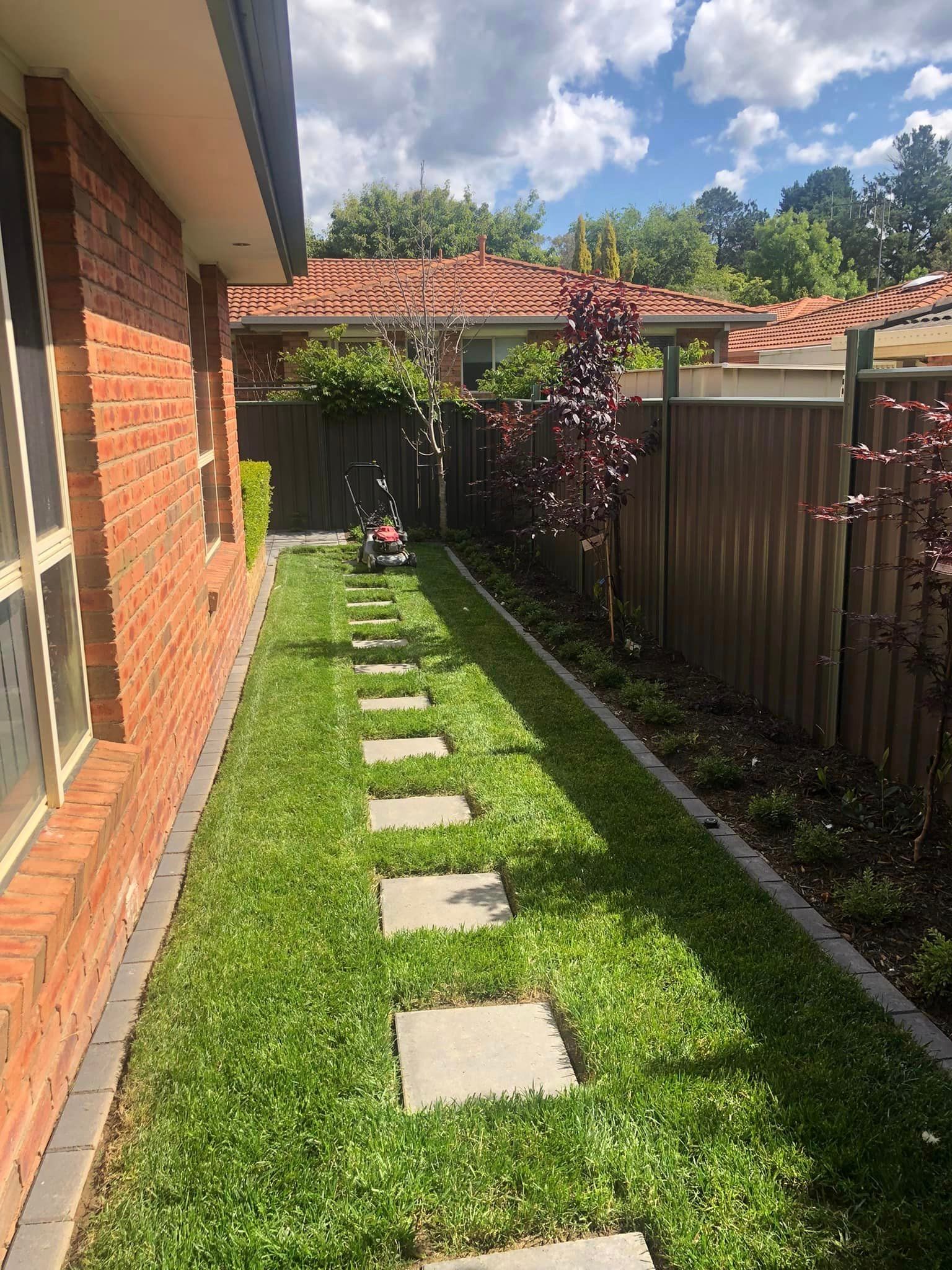 There is a lawn mower in the backyard of a house.