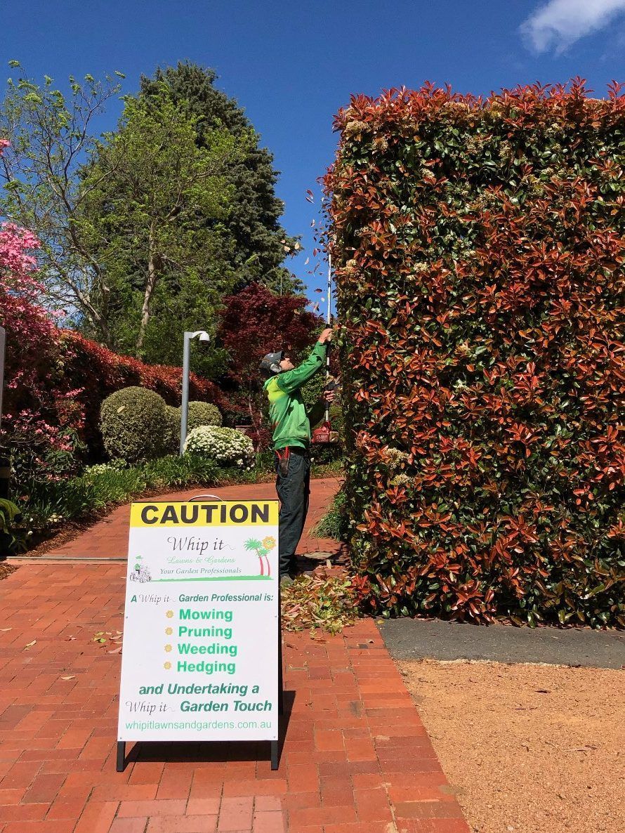 A man is standing next to a sign that says `` caution ''.