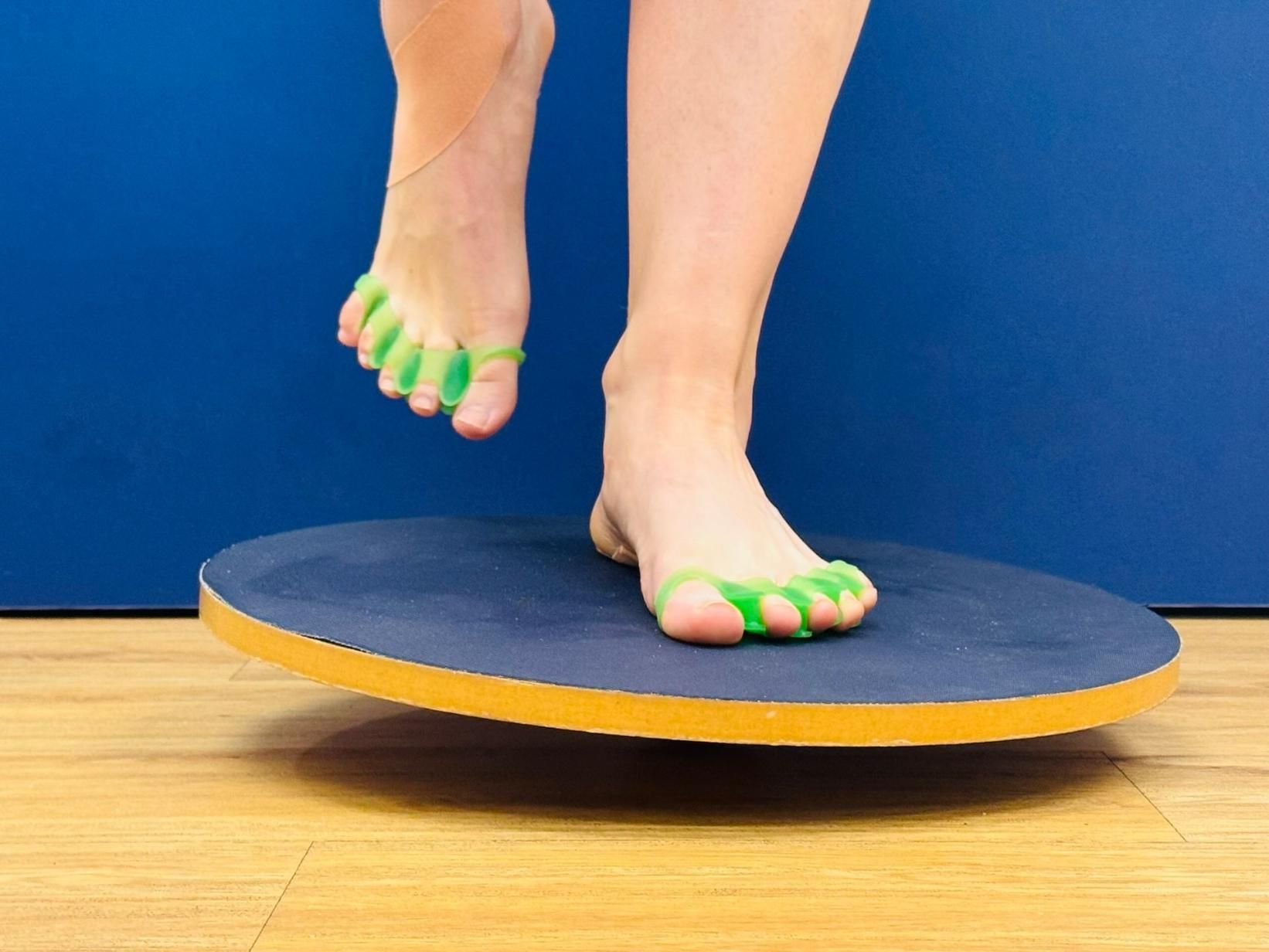 A Person Wearing Toe Spacers Stands on a Balance Board, One Foot Raised — Alice Springs Podiatry in Ciccone, NT