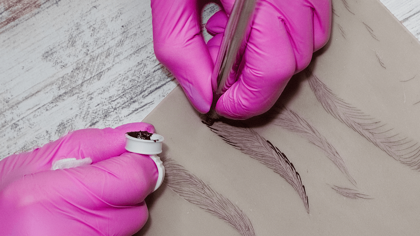 Microblading artist practicing different shading techniques on paper.