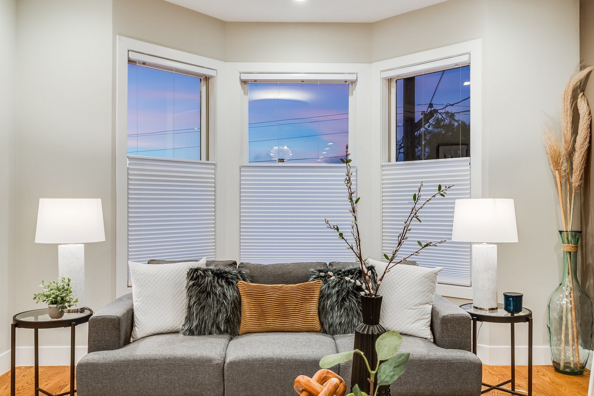 A living room with a couch and two lamps.