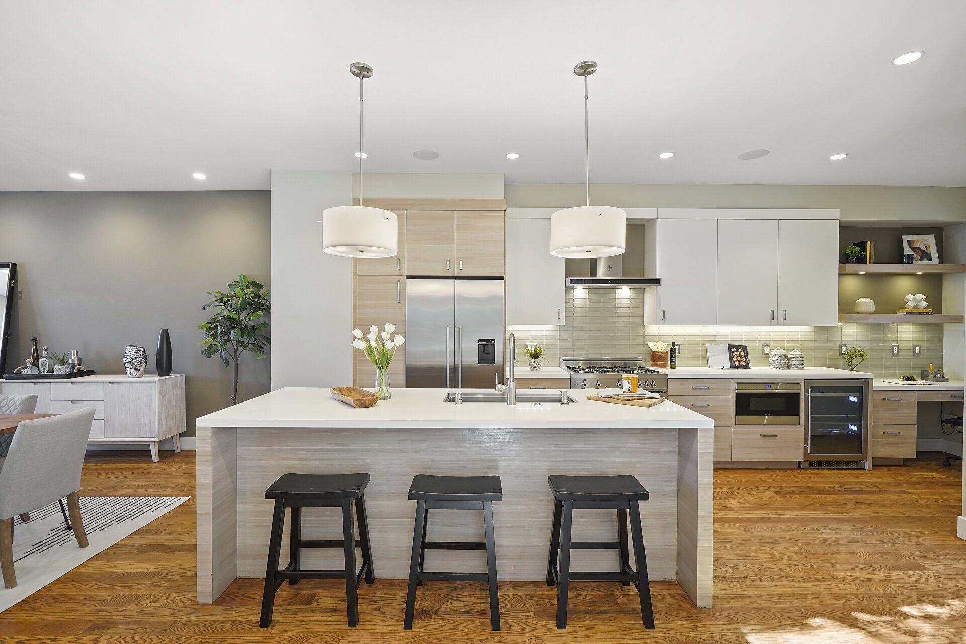 A kitchen with an island and three stools.