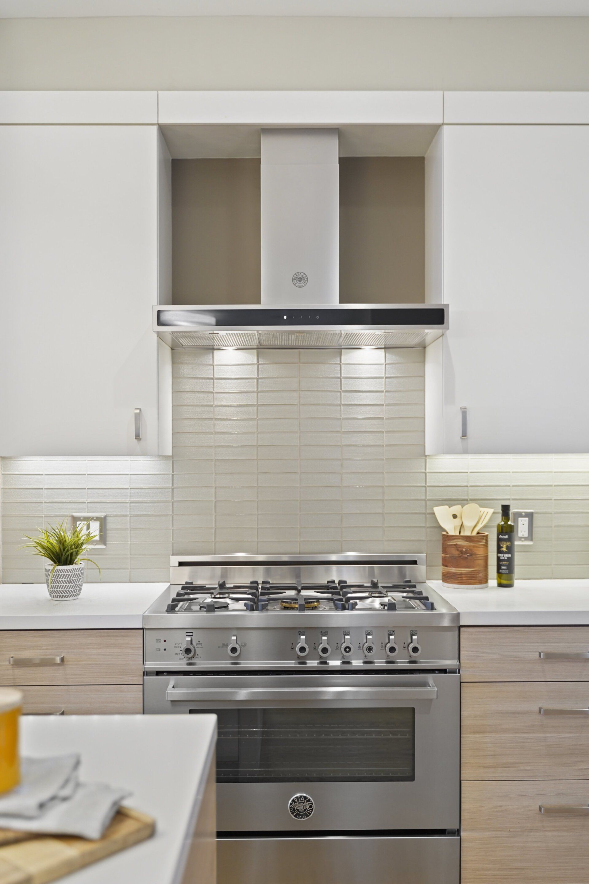 A kitchen with stainless steel appliances and white cabinets.