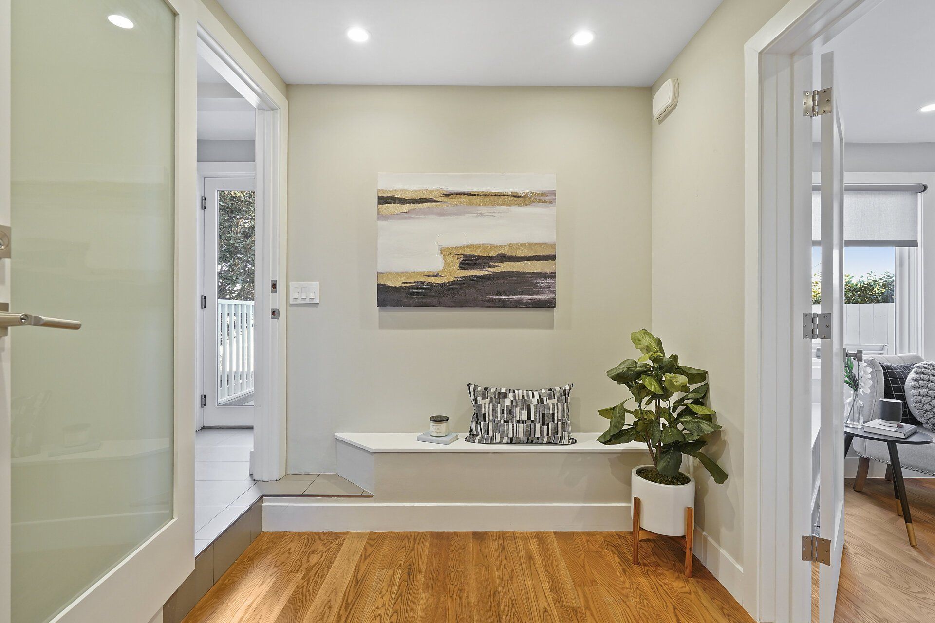 A hallway with hardwood floors and a painting on the wall.