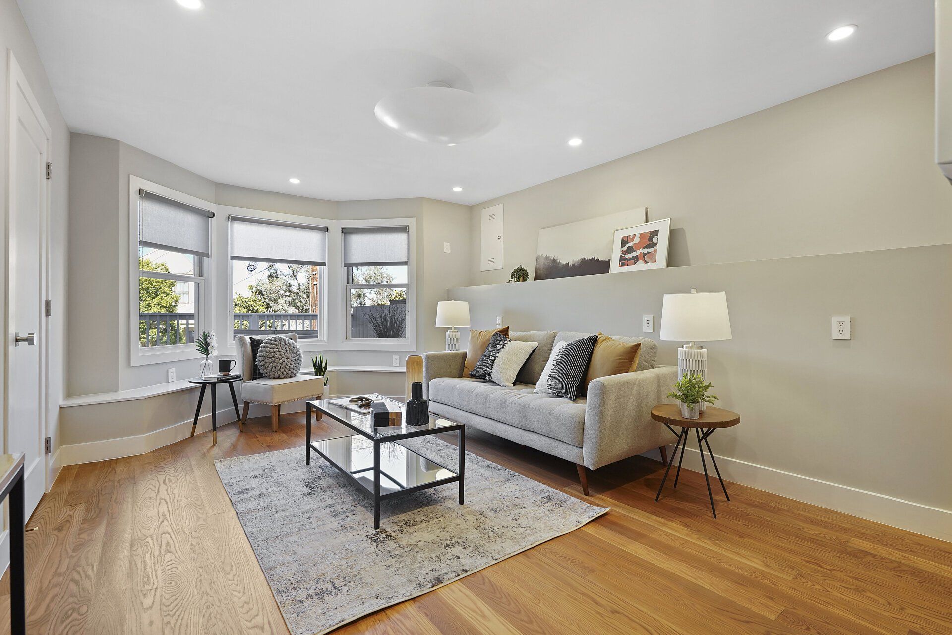 A room with a couch , coffee table , and windows.