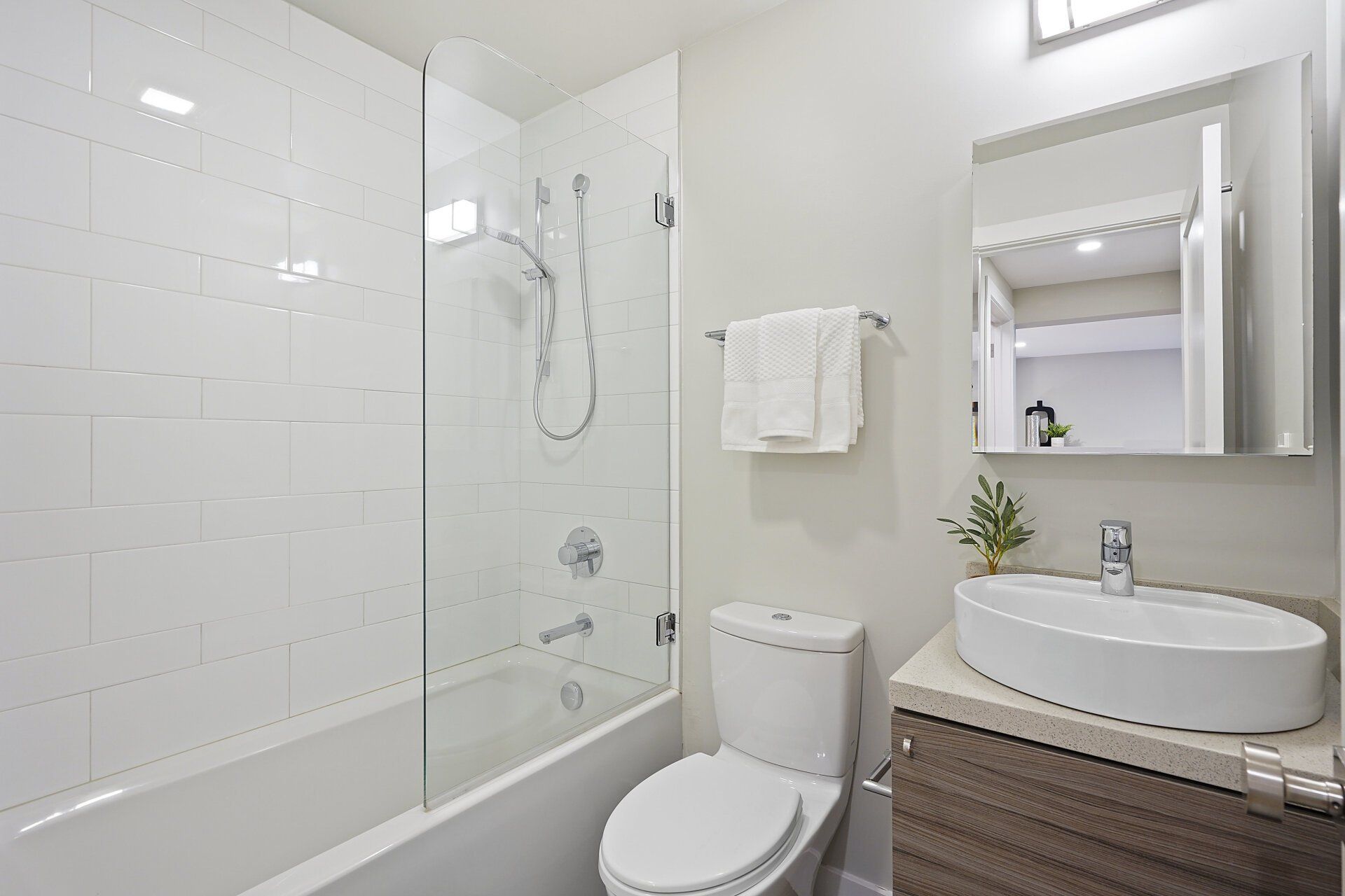 A bathroom with a toilet , sink , bathtub and shower.