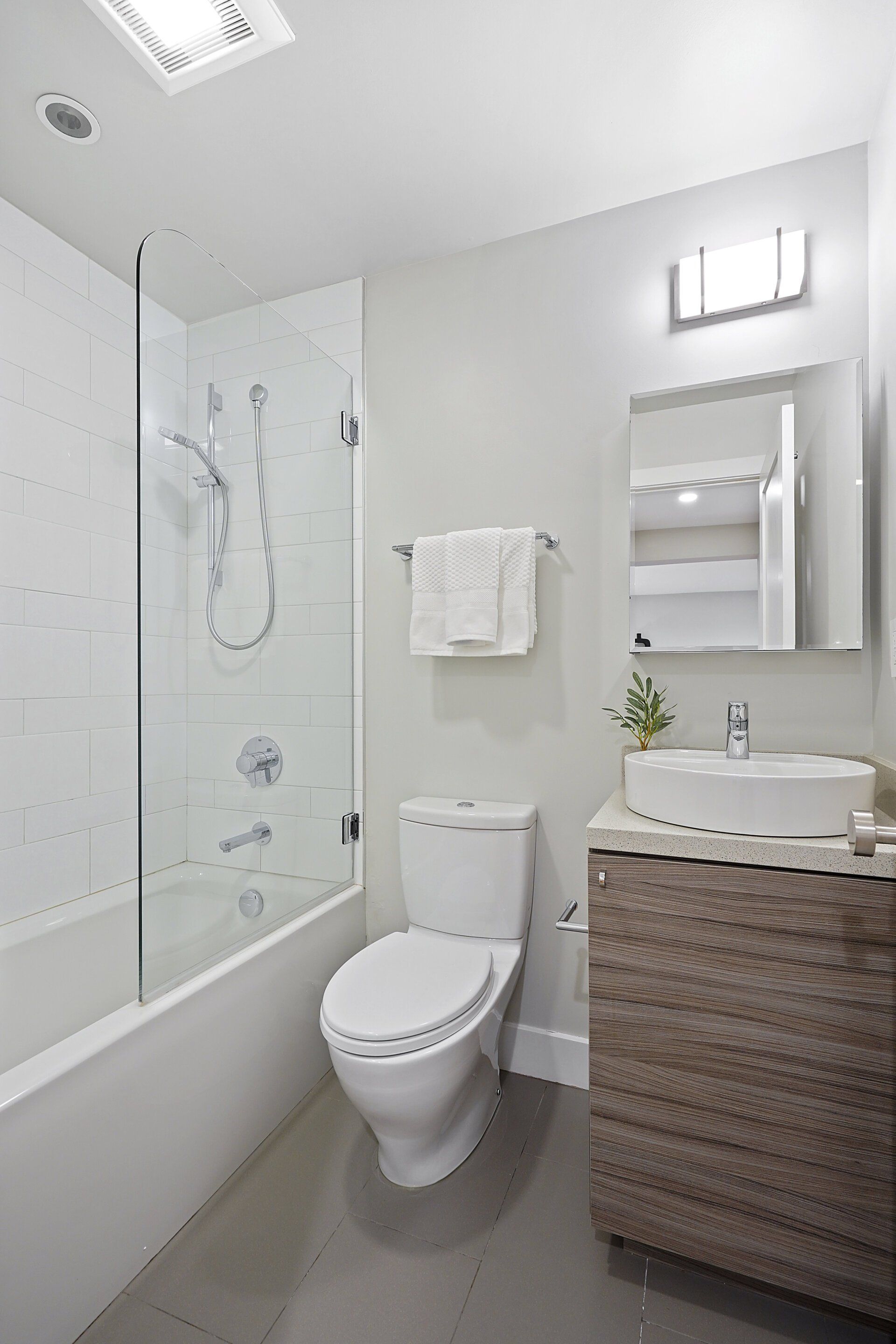 A bathroom with a toilet , sink and bathtub.