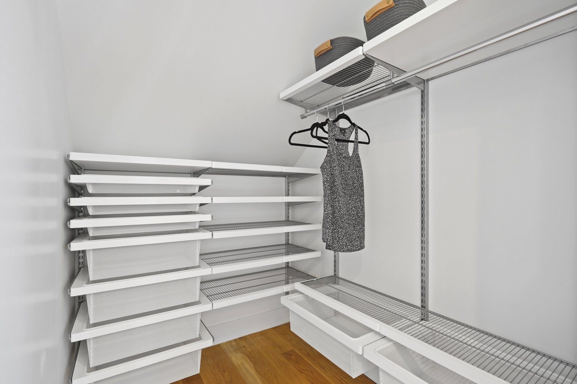 A walk in closet with a dress hanging on a rack.