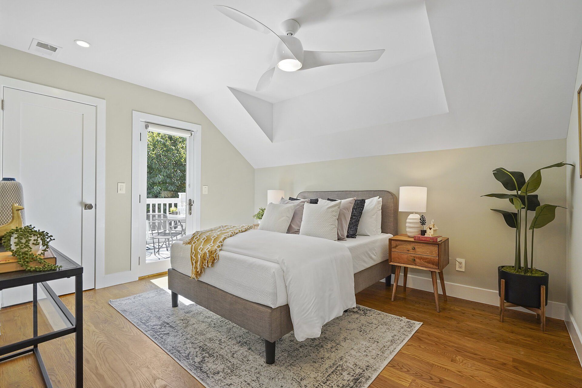 A bedroom with a bed and a ceiling fan.