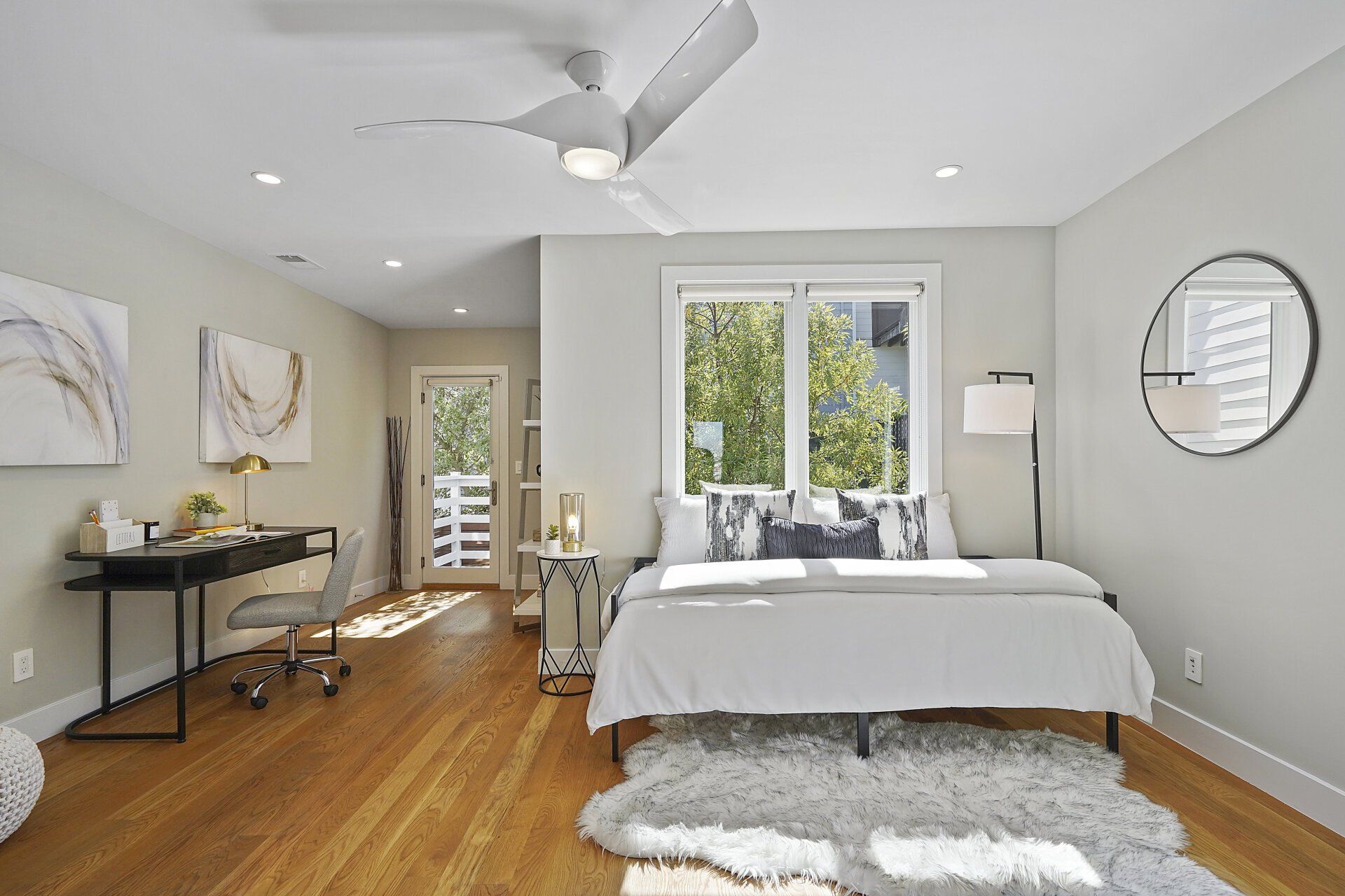 A bedroom with a bed and a ceiling fan.