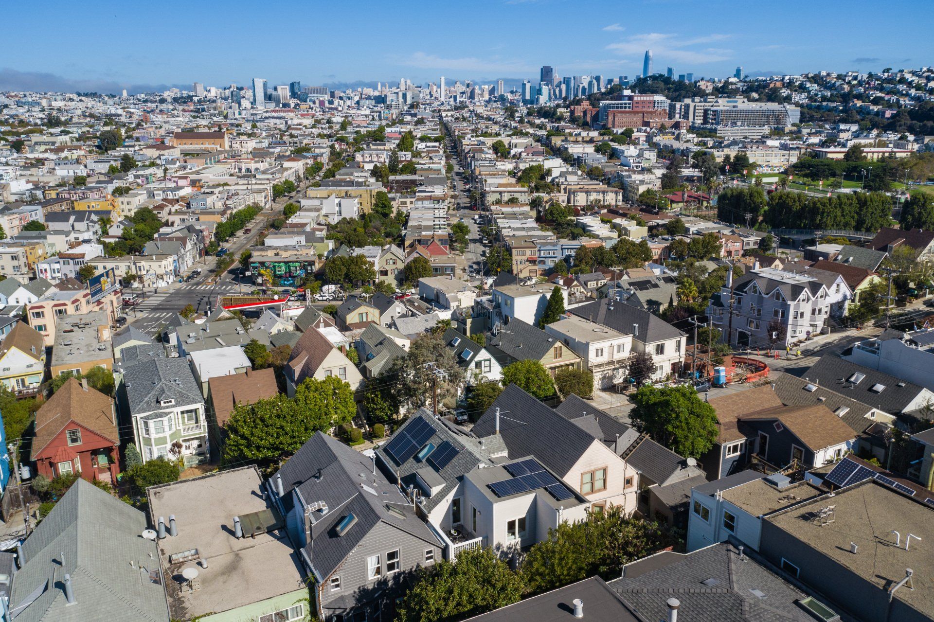 Aerial view of a residential neighborhood in San Francisco, California, with city skyline in the distance.