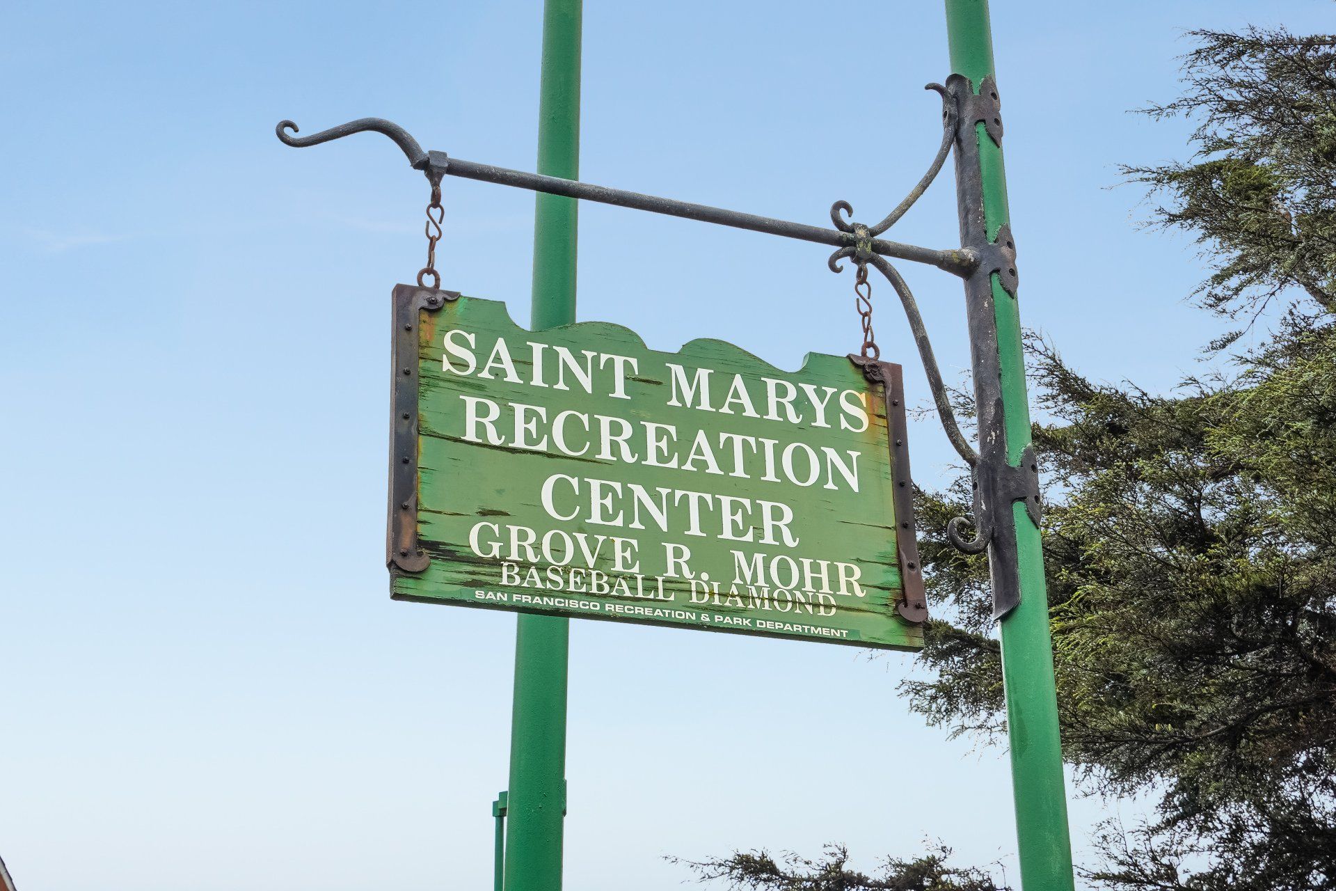 Sign for Saint Mary's Recreation Center, Grove R. Mohr, green with black metal detailing, against a blue sky.