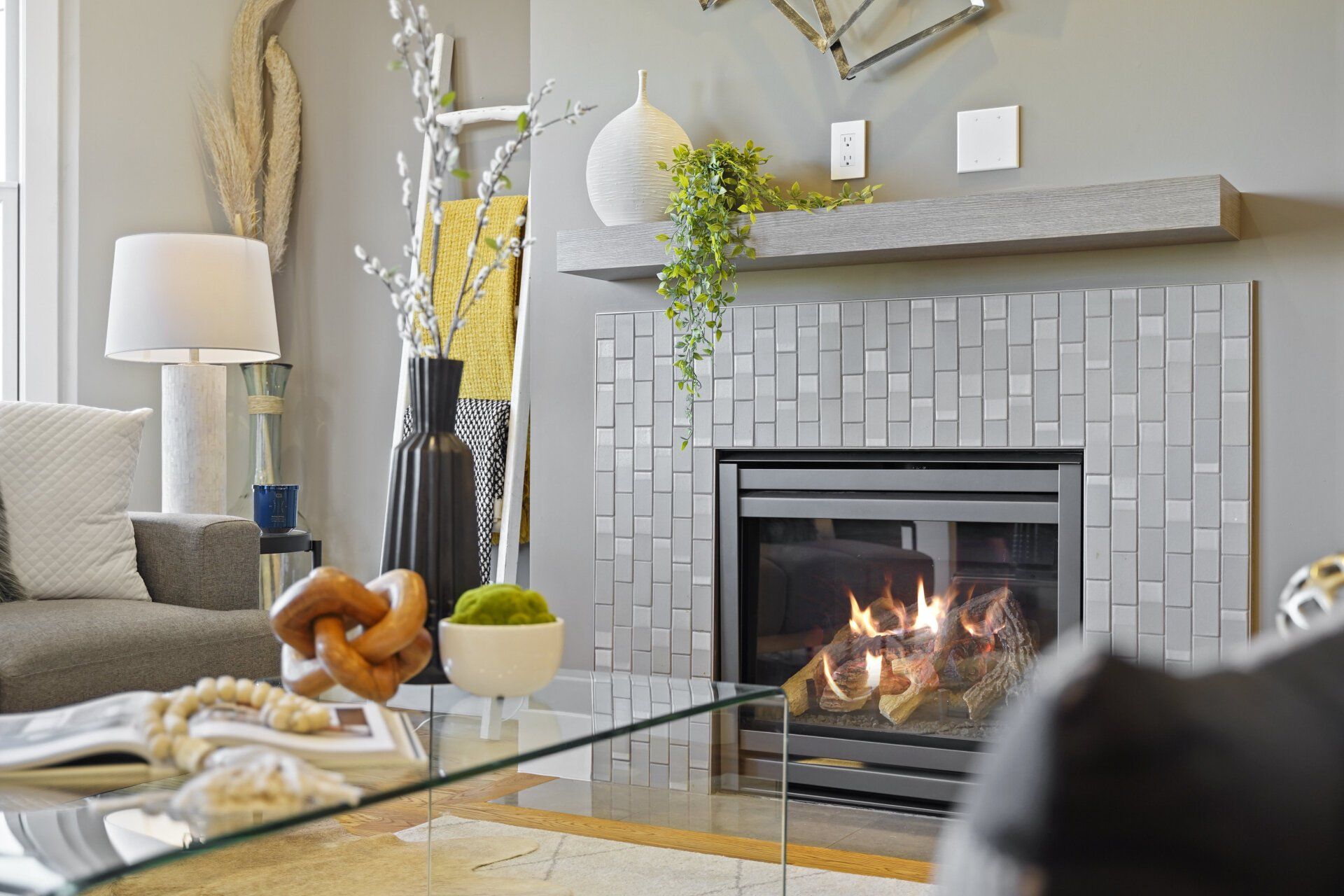 A living room with a fireplace and a glass coffee table.