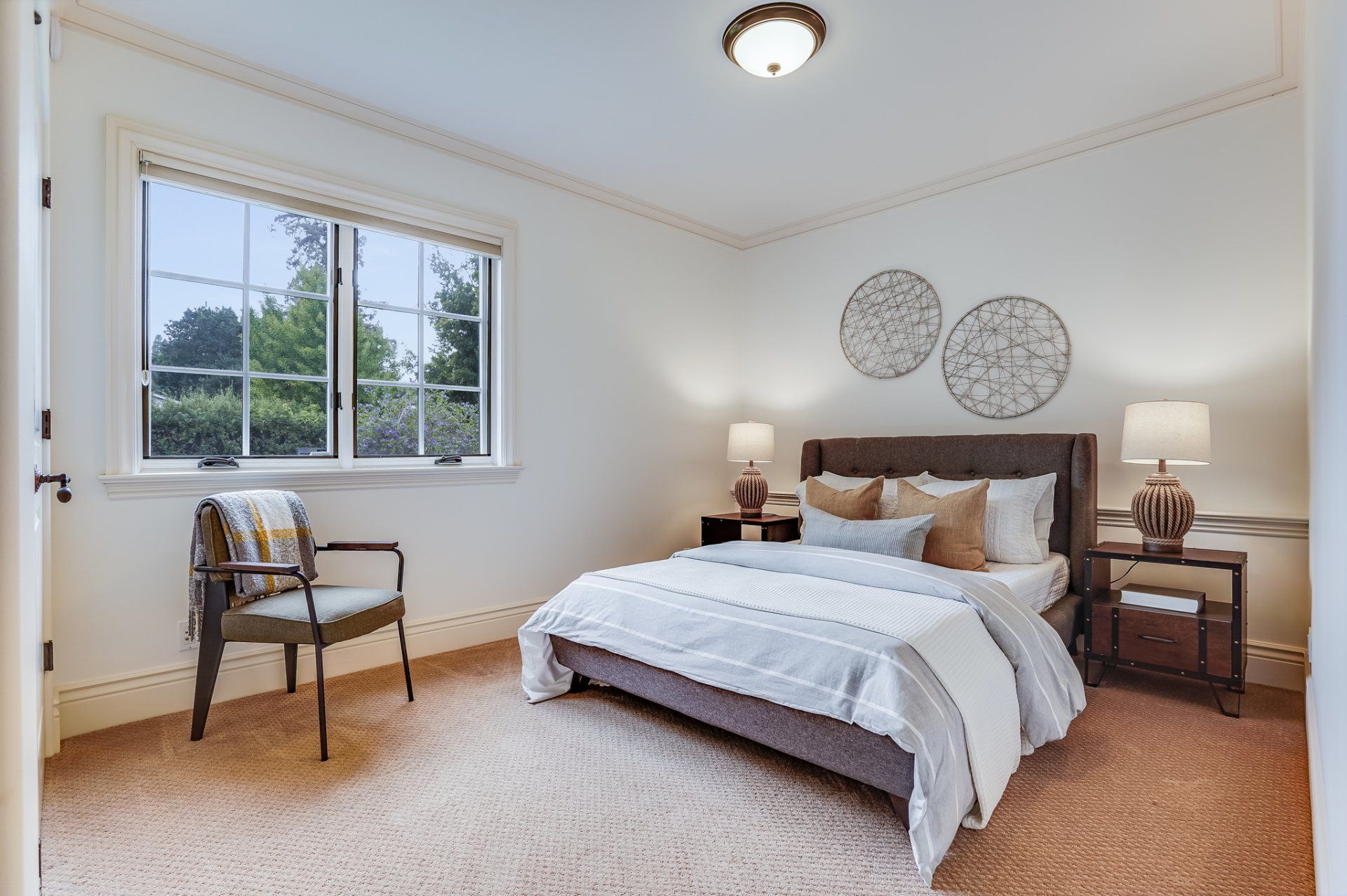 A bedroom with a bed and a chair