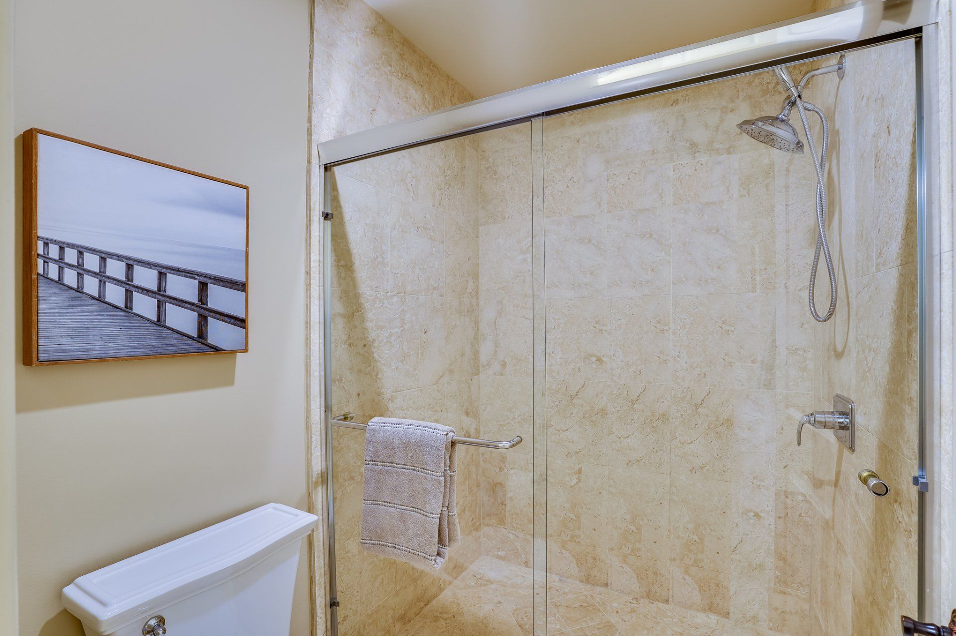 A bathroom with a toilet and a shower with sliding glass doors