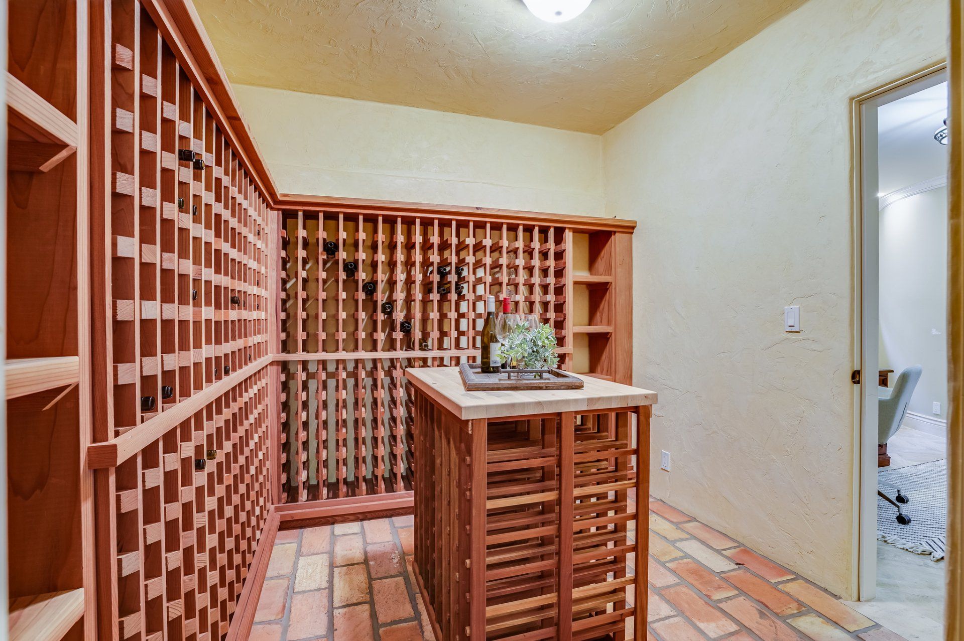 A large wine cellar with lots of shelves and a table.