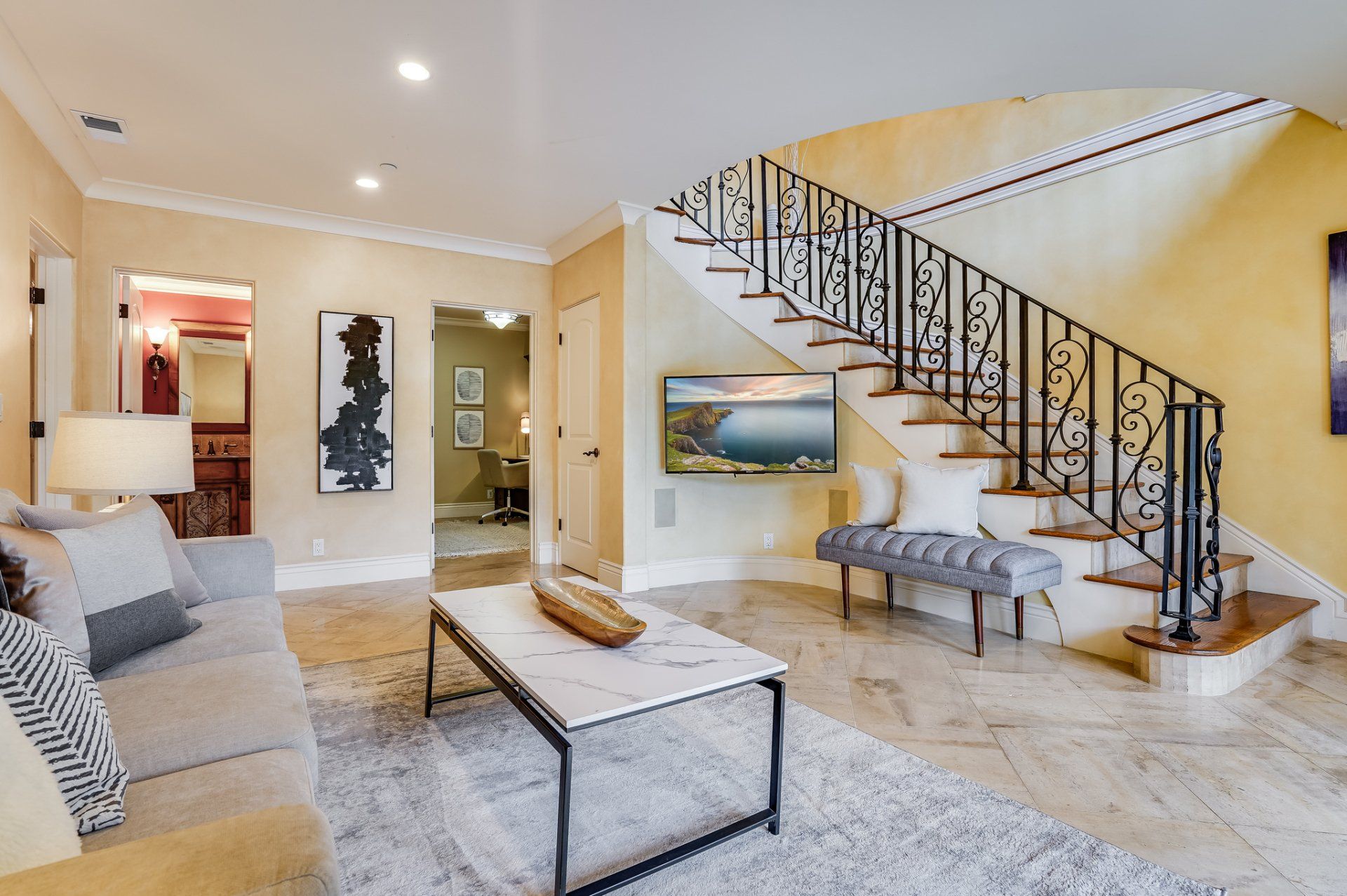 A living room with a couch , coffee table , and stairs.