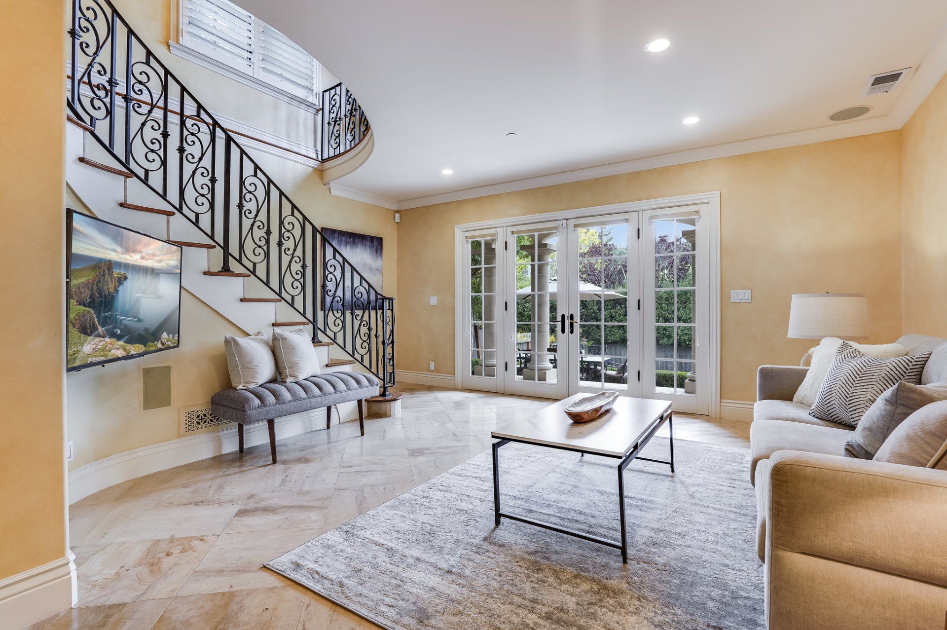 A living room with a couch , coffee table , and stairs.