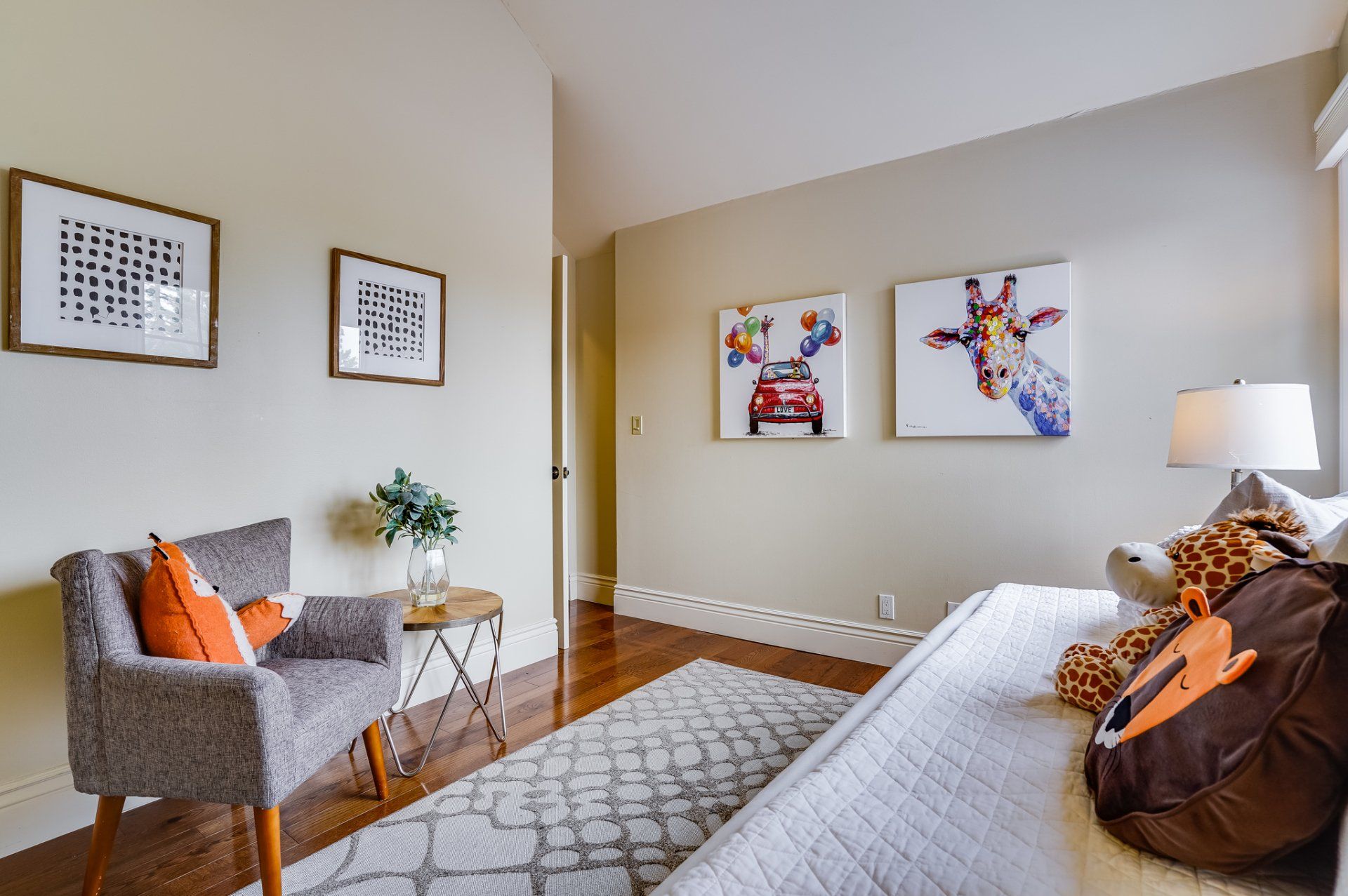 A bedroom with a bed , chair and paintings on the wall