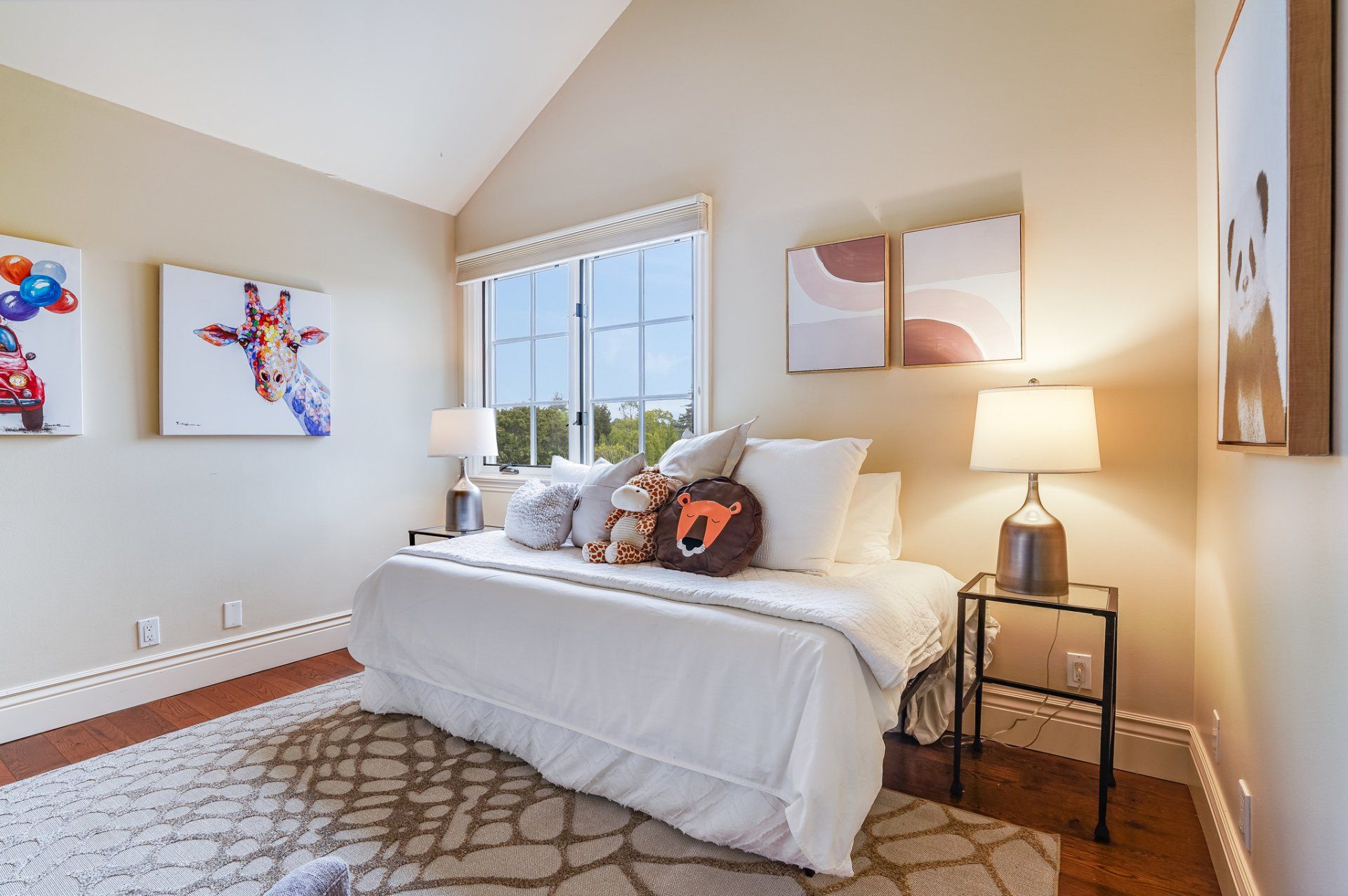 A bedroom with a bed , lamps , a rug and a window.