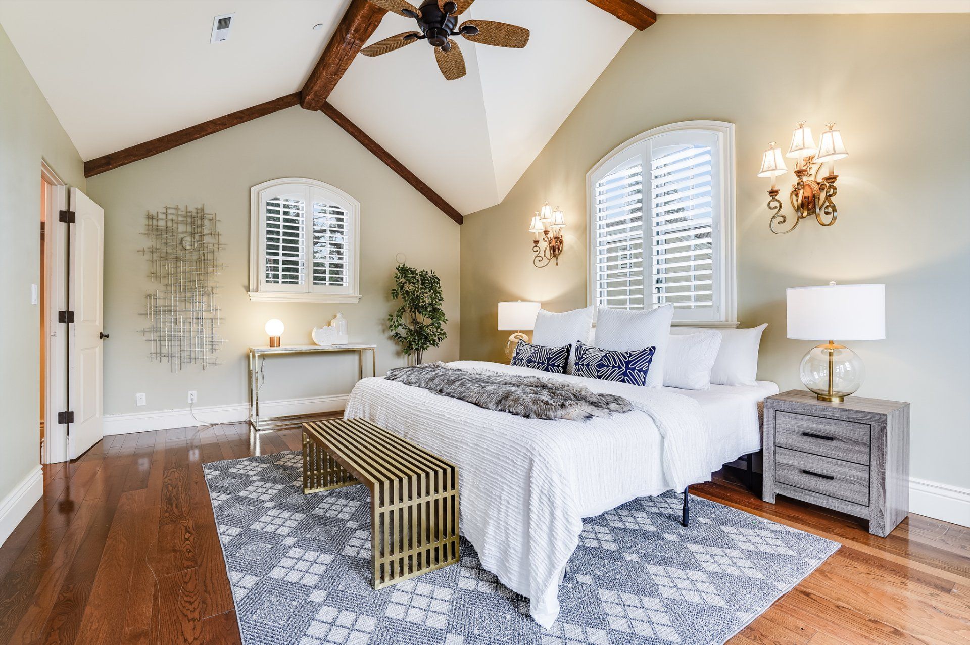 A bedroom with a ceiling fan and a large bed