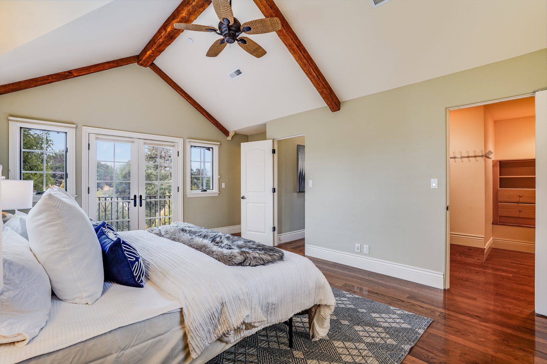 A bedroom with a large bed and a ceiling fan