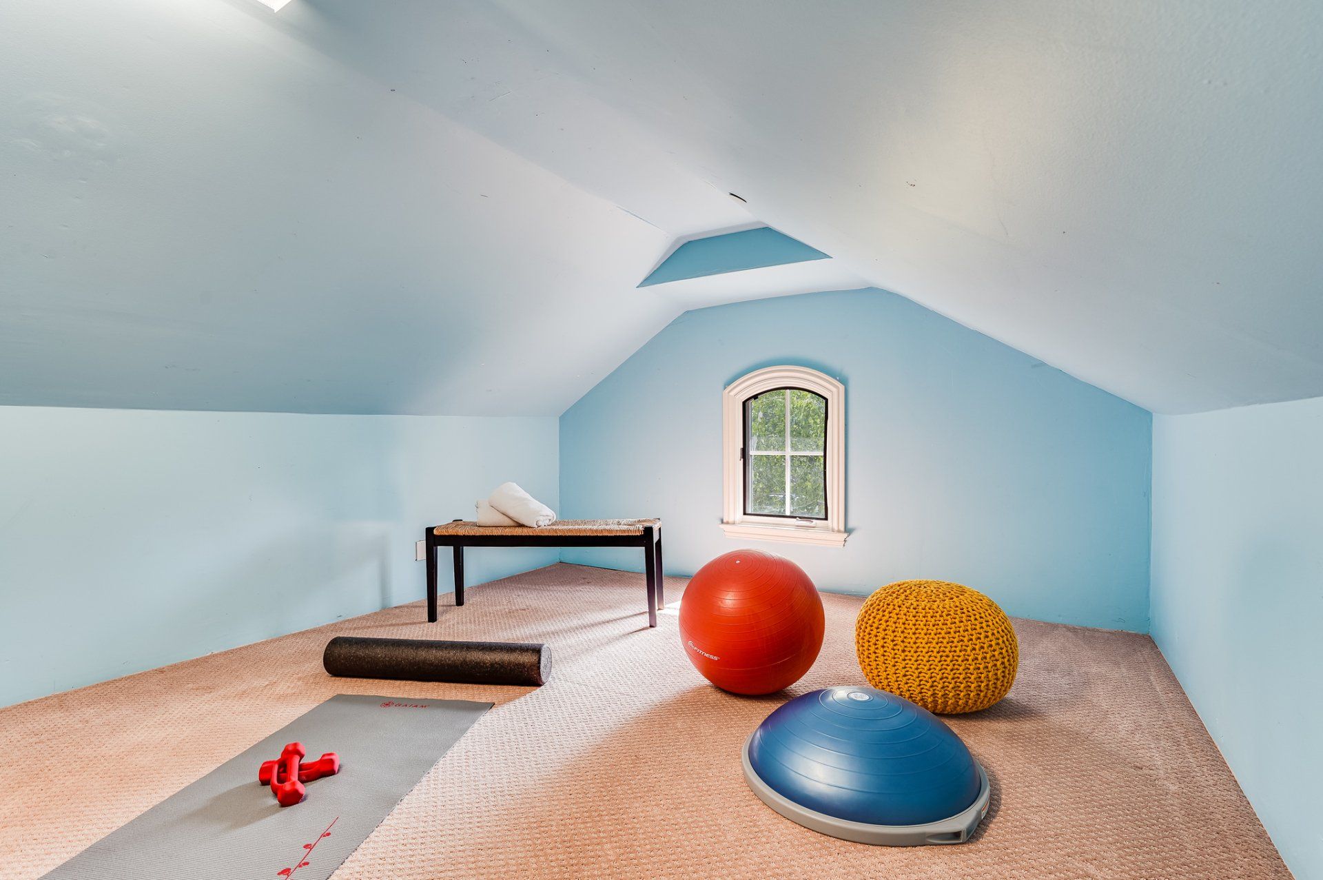 An attic with a yoga mat and exercise balls