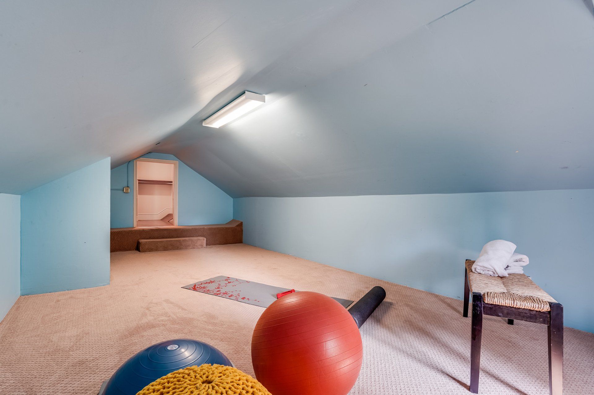 An attic with exercise balls and a stool