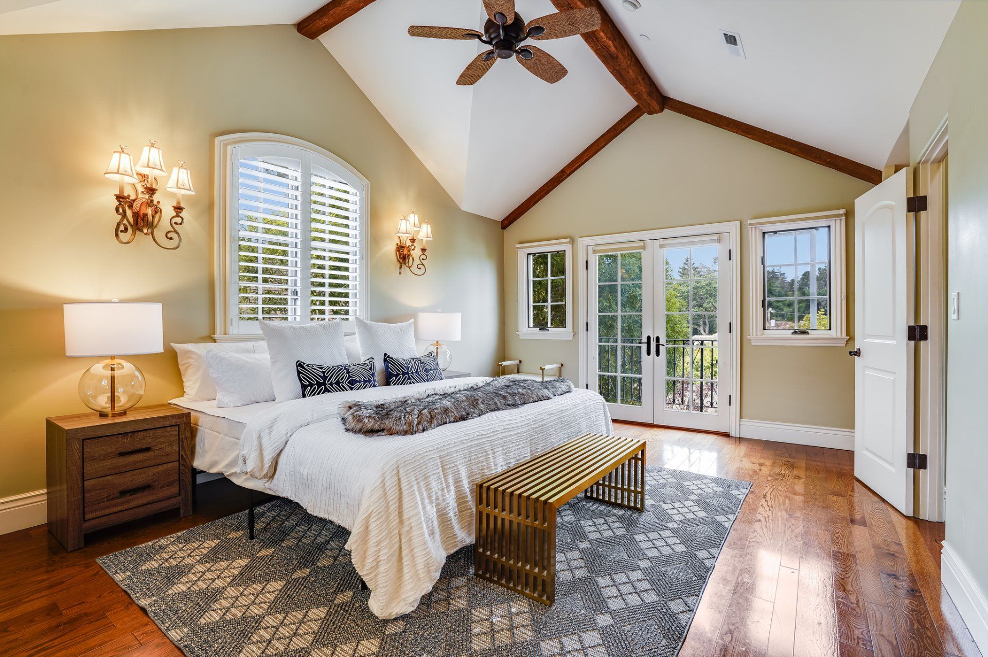 A bedroom with a large bed and a ceiling fan.