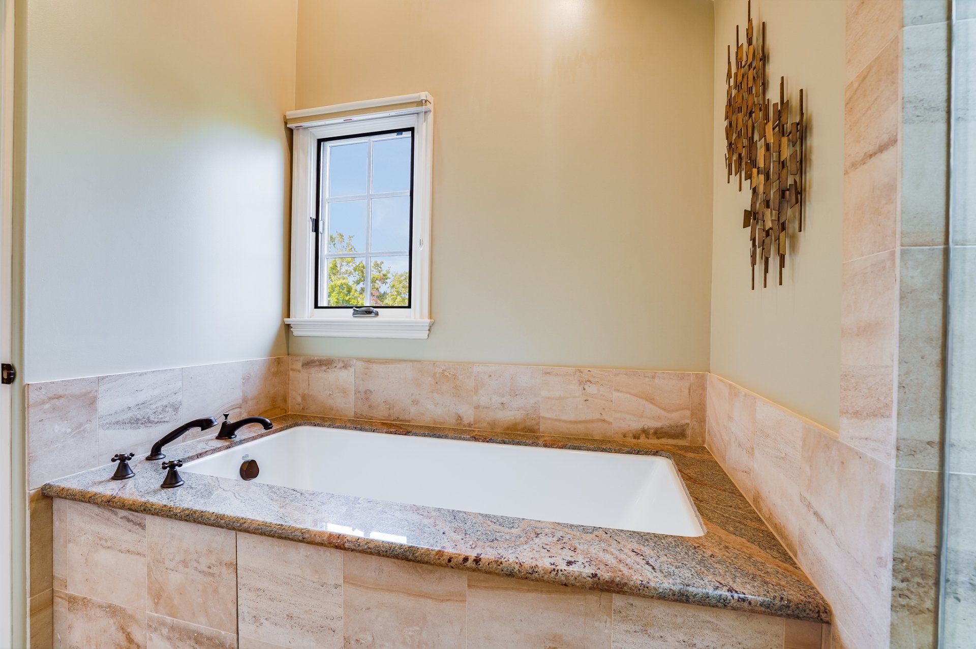 A bathroom with a bathtub and a window.