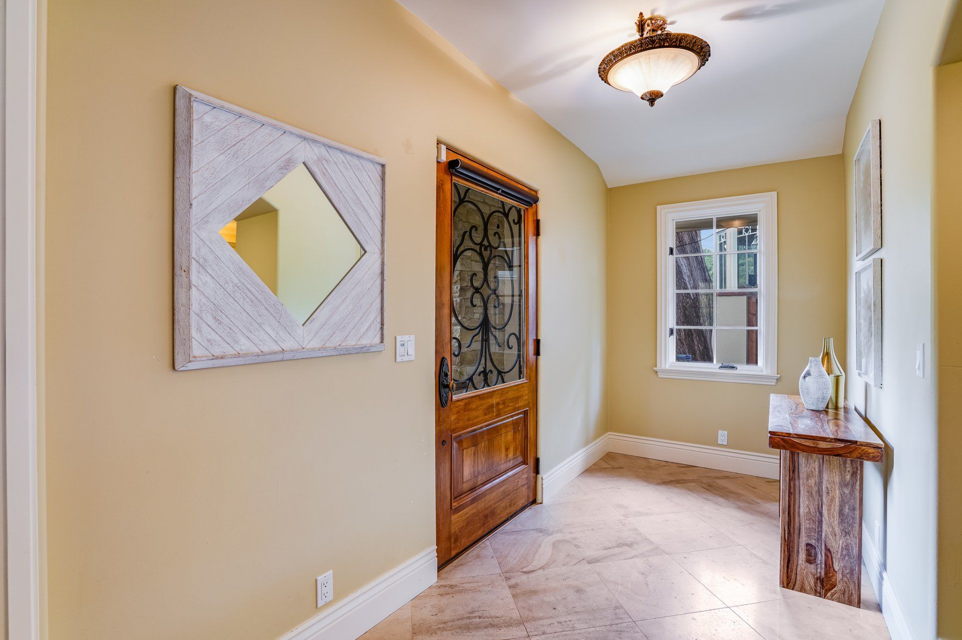 A hallway with a wooden door and a mirror on the wall