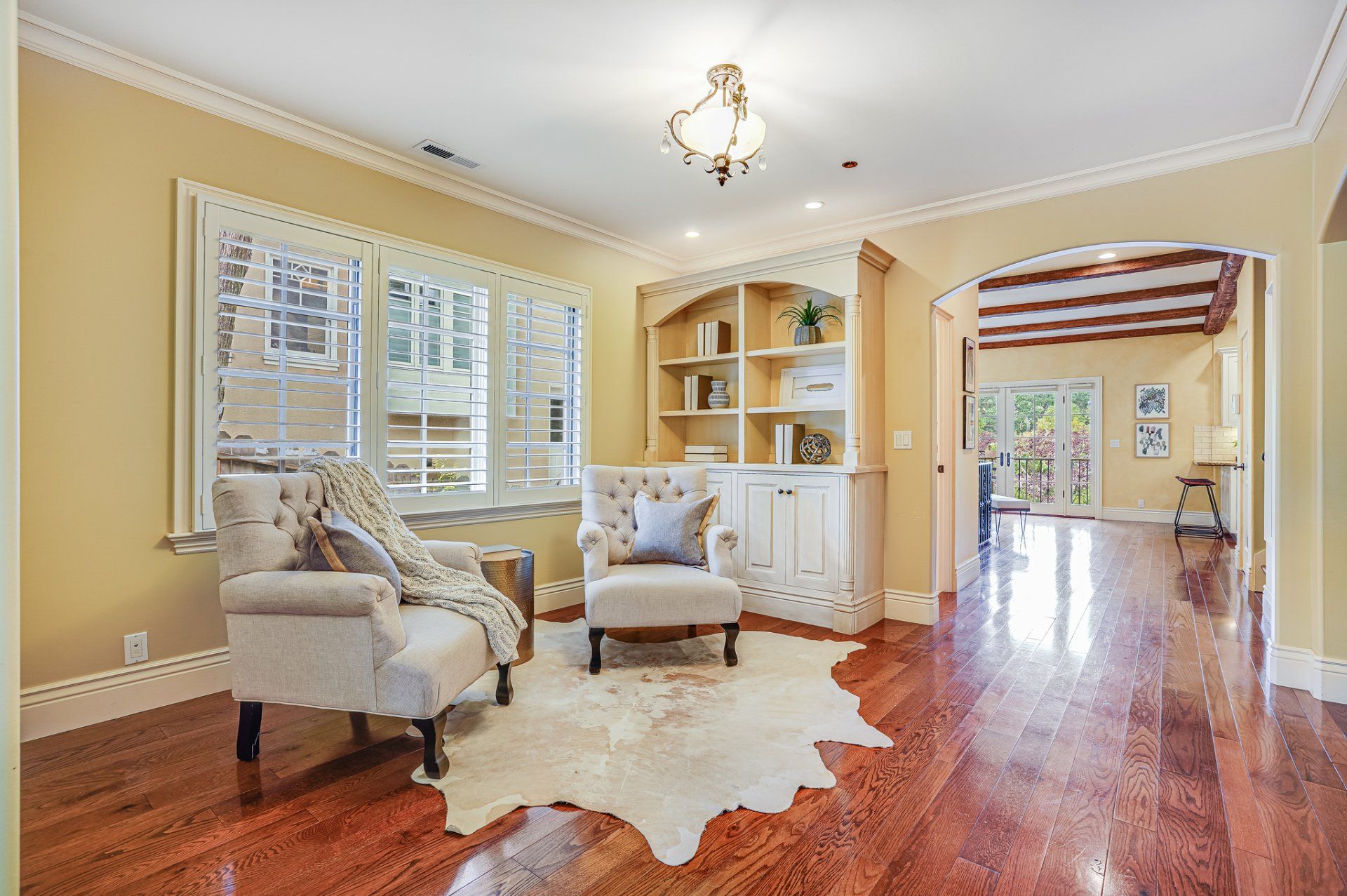 A living room with hardwood floors and a cowhide rug.