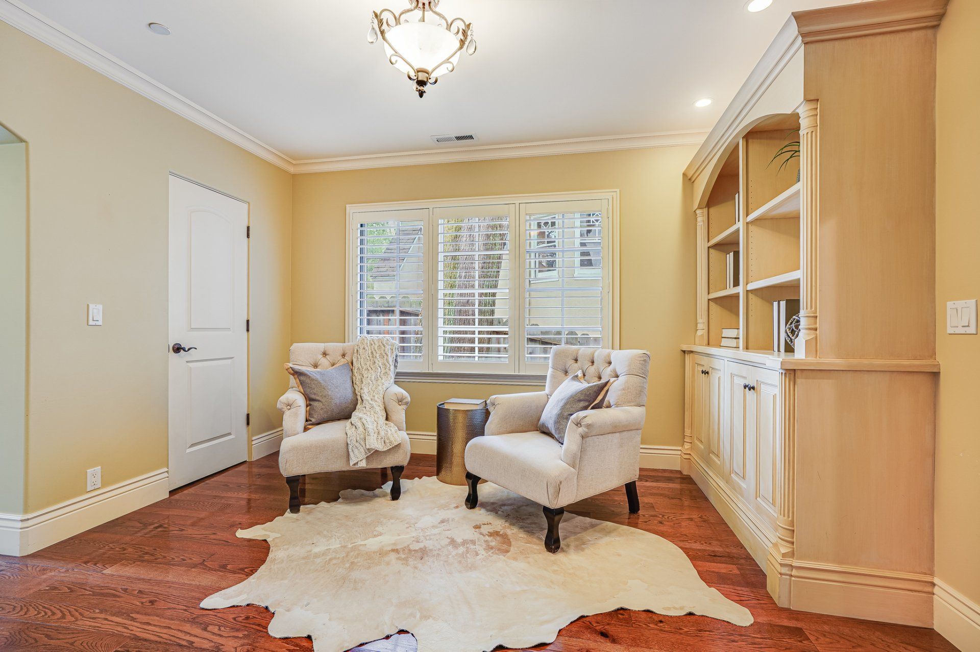 A living room with two chairs and a cowhide rug